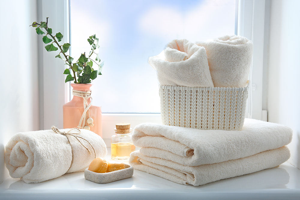 Folded towels stack,essential oil and soap on window