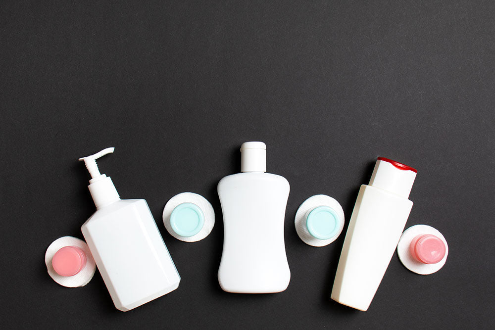 Travel-size shampoo and conditioner bottles with caps and cotton pads