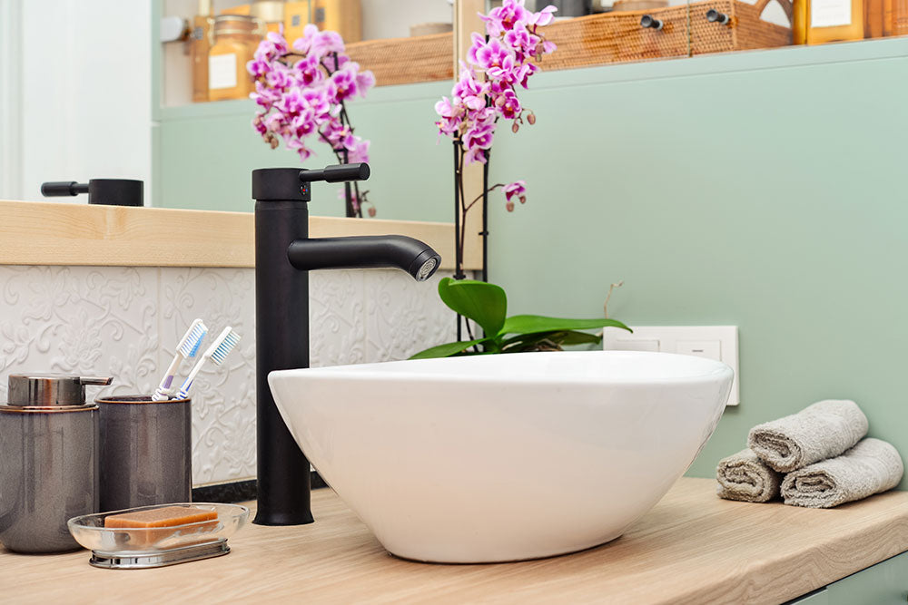 Stylish vessel sink with black basin mixer on light
