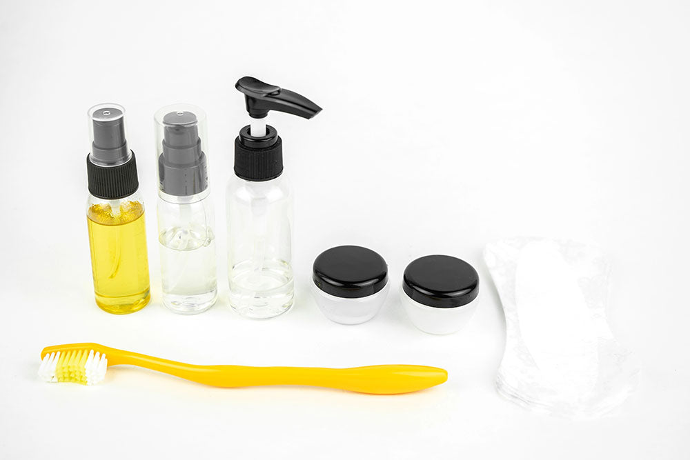 Travel sized toiletries including small bottles, jars, and a toothbrush