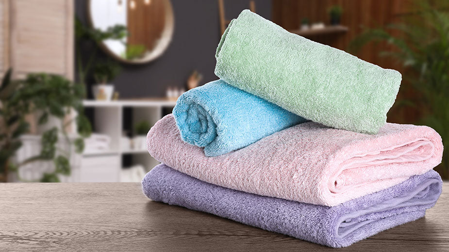Fresh towels on wooden table in bathroom 
